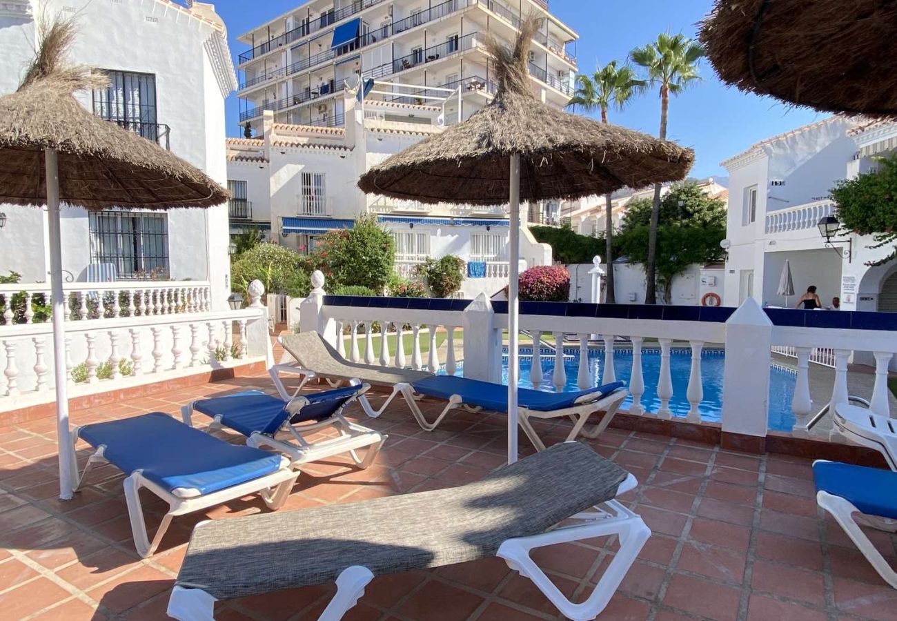 Bains de soleil et parasols au bord de la piscine à Nerja