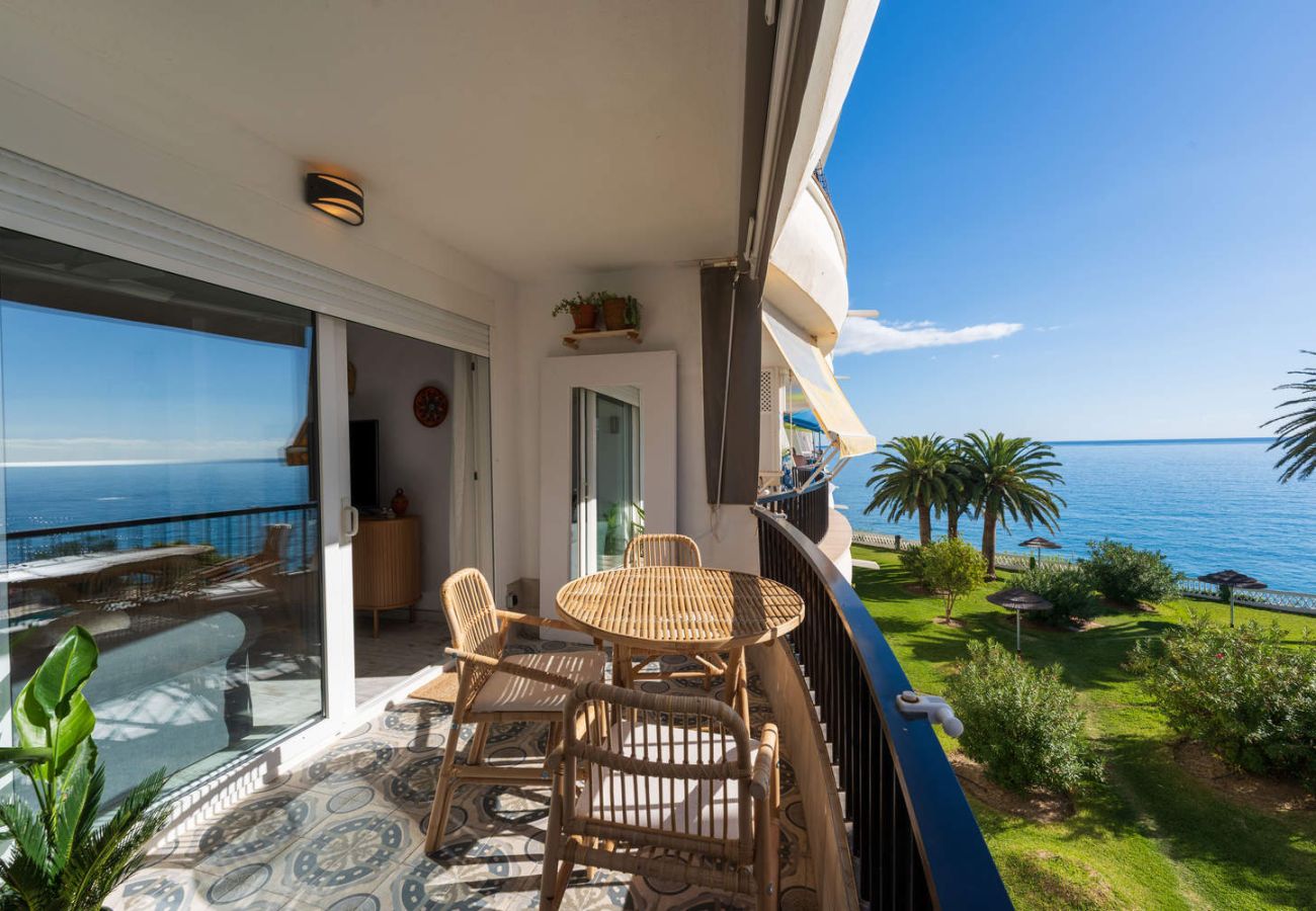 Balcon de l'hébergement avec ciel ensoleillé et vue sur la mer et le jardin