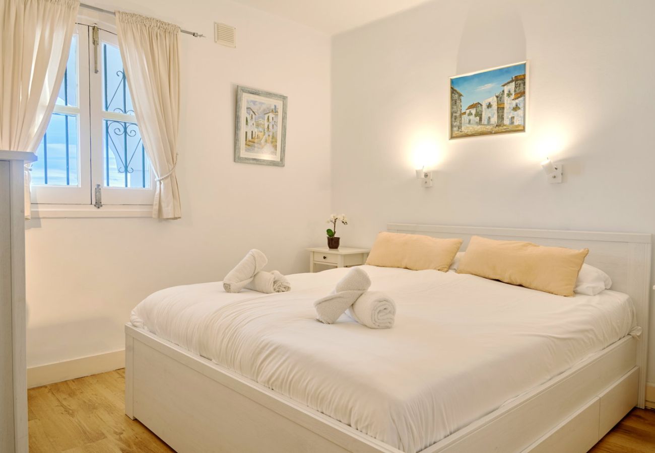 Chambre principale avec lit double et lumière naturelle en location de vacances.