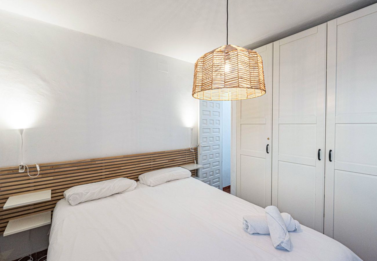 Chambre principale avec grand lit, matelas haut de gamme et armoire.