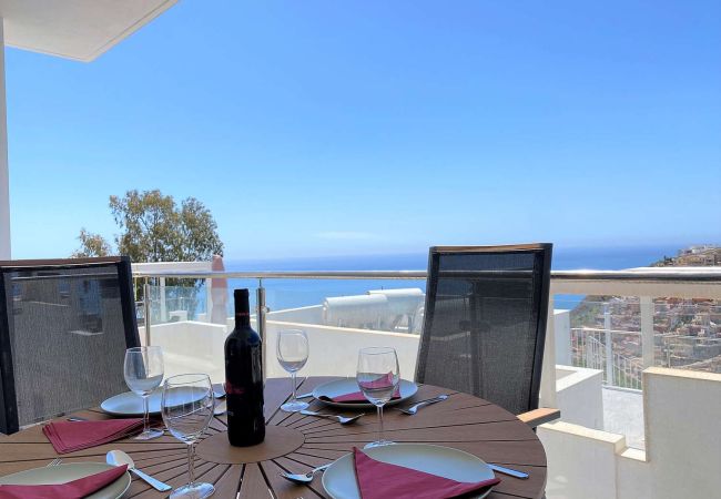Table à manger sur une terrasse moderne avec vue frontale sur la mer à Nerja.