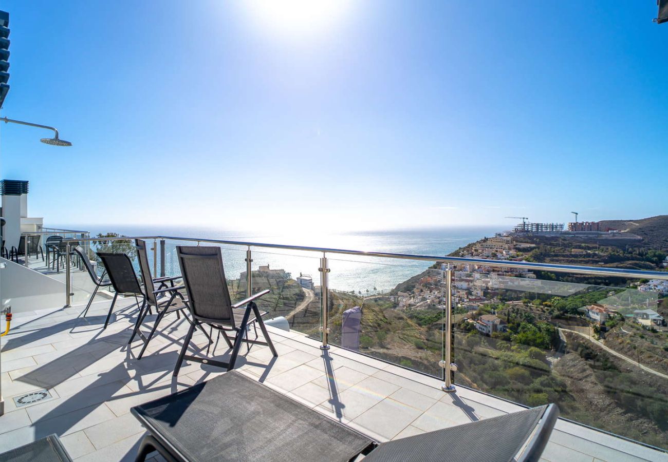 Terrasse solarium privée avec barbecue, chaises longues et vue mer dans un attique en duplex à Nerja.