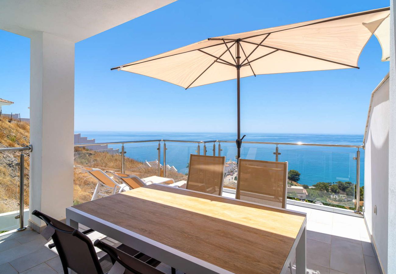 Terrasse privée avec table à manger et vue panoramique sur la Méditerranée lors d'une journée ensoleillée à Nerja.