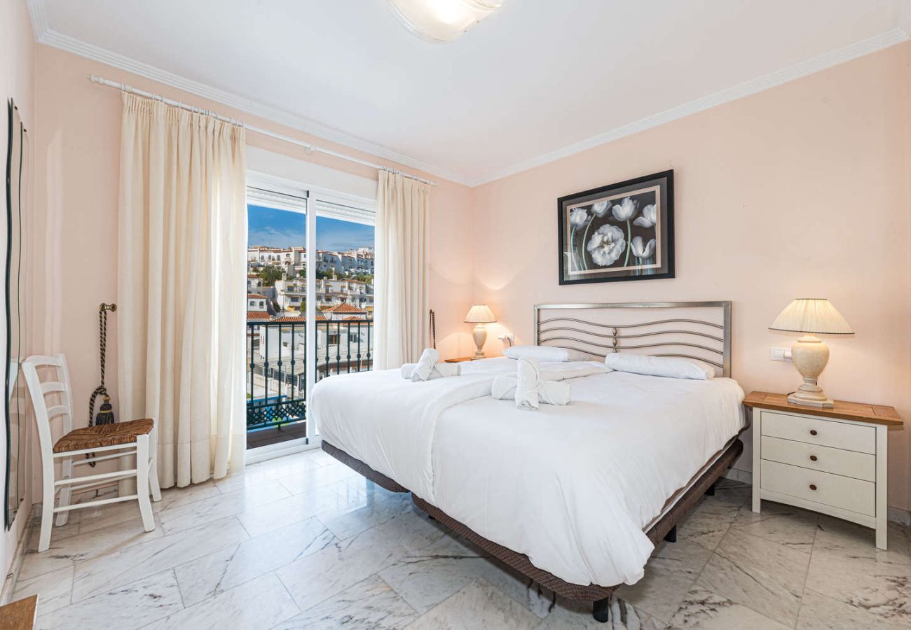 Chambre principale avec lit double et balcon privé près de la plage à Nerja.