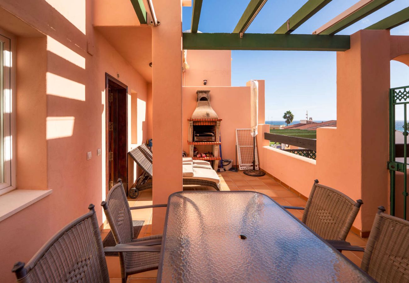 Toit-terrasse privé avec barbecue, chaises longues et vue mer à Nerja.