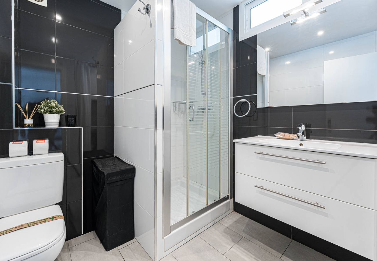 Salle de bain avec douche et lave-linge dans le logement