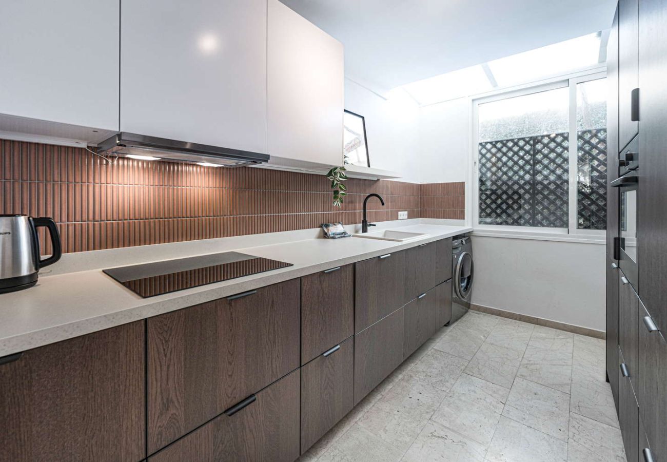 Cuisine moderne entièrement équipée avec four, micro-ondes et design élégant dans un logement de vacances.