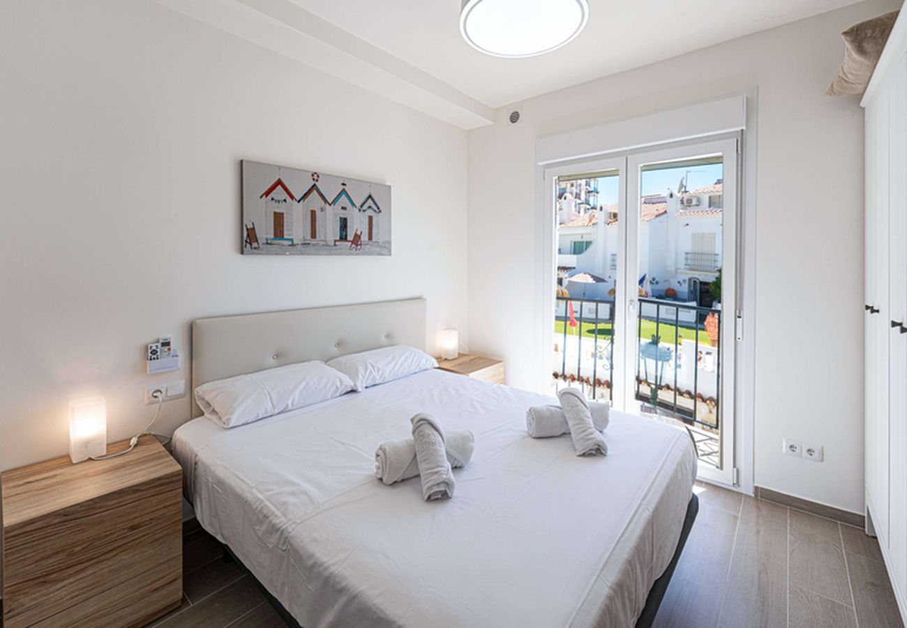 Chambre principale chaleureuse avec un lit double dans l'appartement à Nerja.