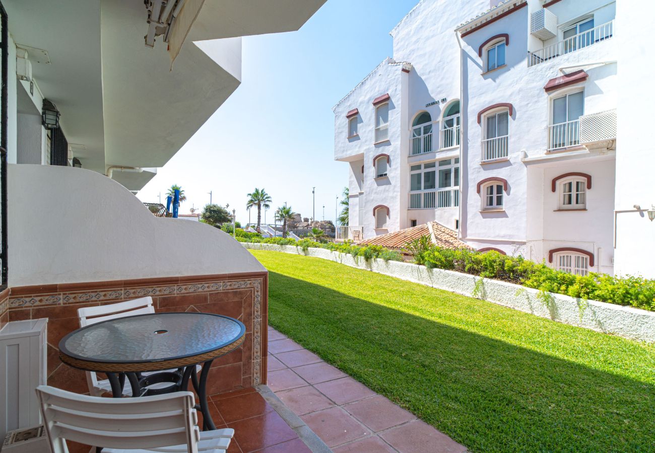 Terrasse d'entrée de l'appartement Arce 2 avec table et chaises face au jardin communautaire.